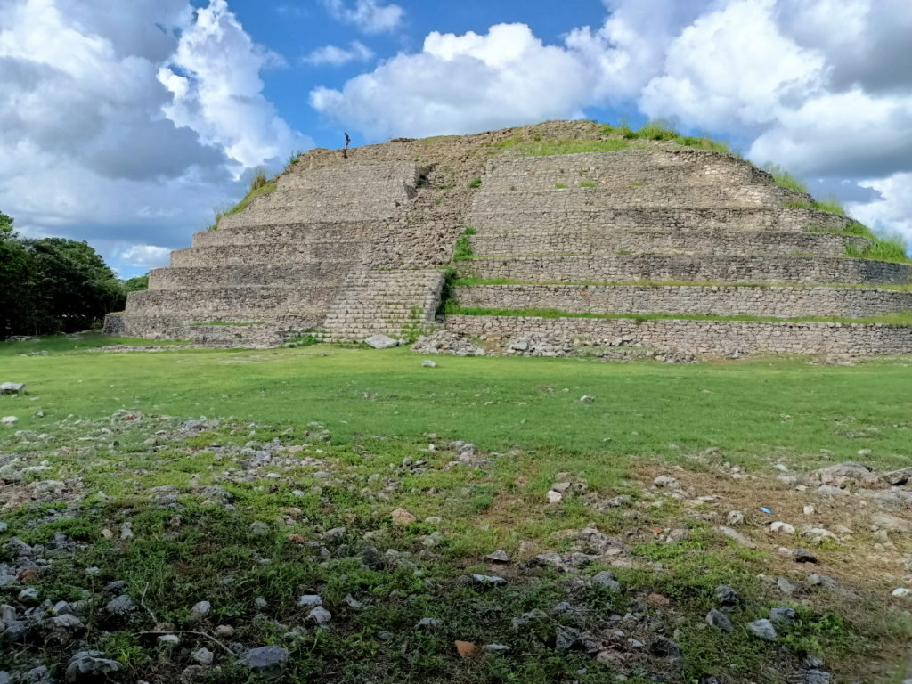 The grassy platform is the top of a very large pyramid supporting this smaller pyramid structure.